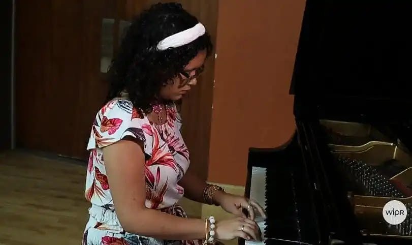 Nikole gracing the keys with her piano performance at WIPR radio station.